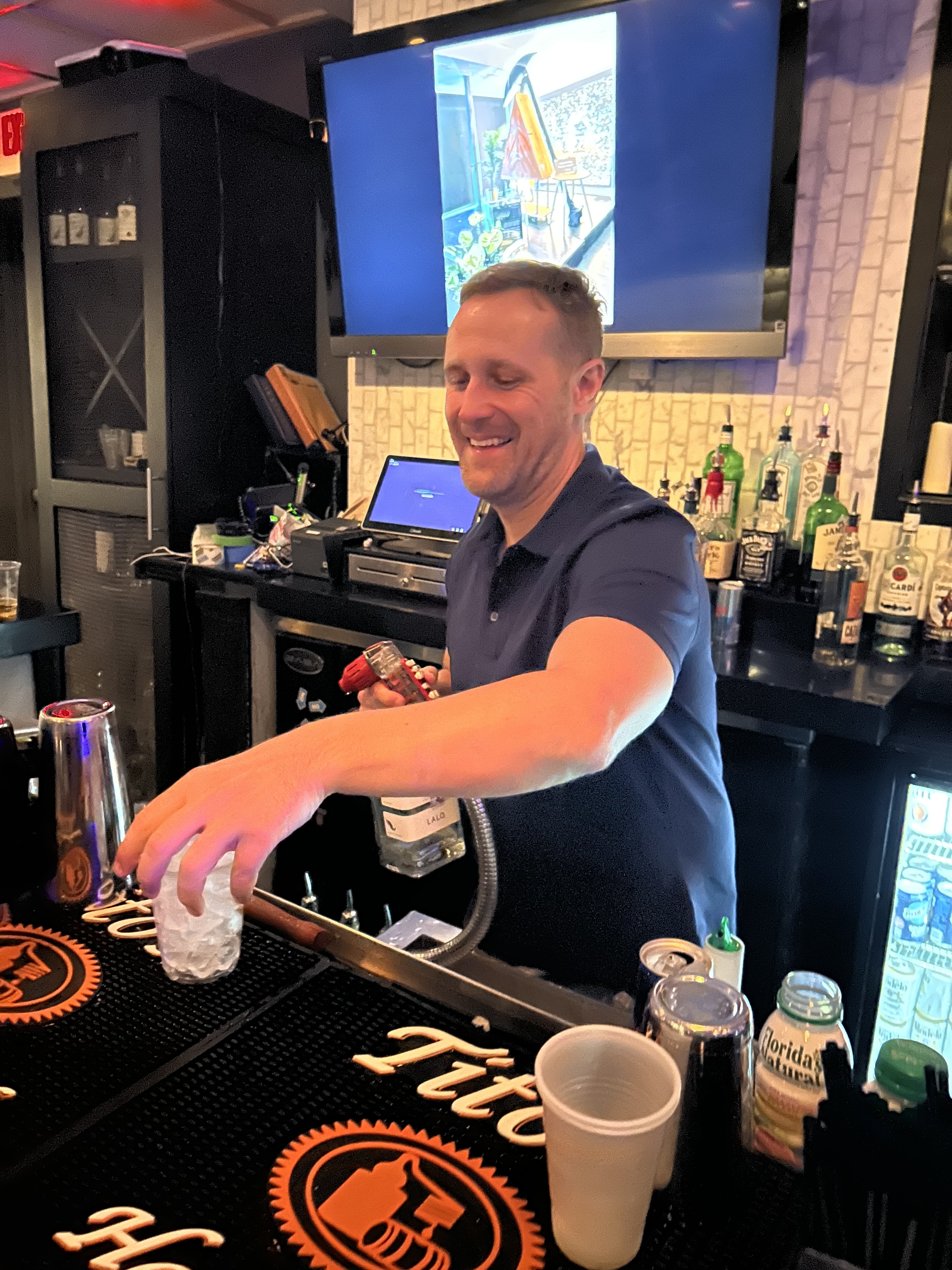 Bartender pouring a drink behind the bar
